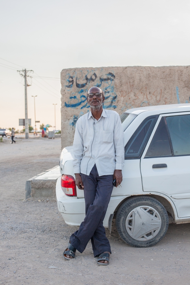 In Bandar Abbas, Eshagh is leaning against one of the most sold cars in Iran, a Kia Pride. The nearly extinct cult car is the Peykan. © Courtesy of Mahdi Ehsaei 